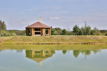 Fototapeta premium log house on the lake with reflection in summer