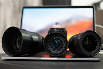 A laptop and three lenses, a photographer, working at home