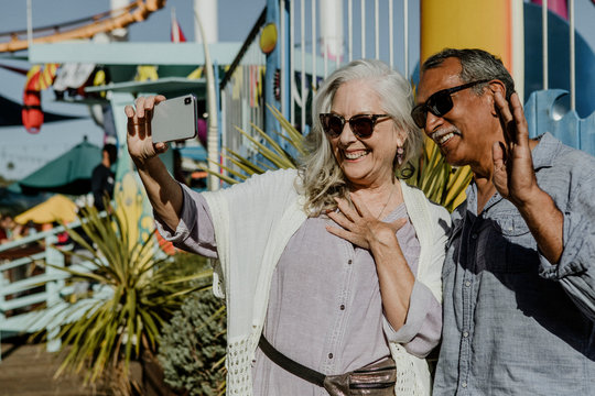 Senior couple taking a selfie in a theme park