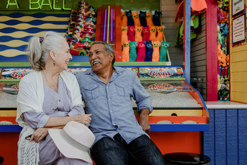 Obraz premium Smiling senior couple resting by a game booth