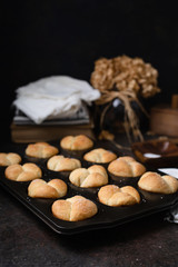 Freshly Baked Homemade Cloverleaf Rolls in Muffin Tin: Rustic, Dark Background