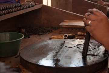 Fototapeta premium Agile hands rolling the addictive cigar for humanity