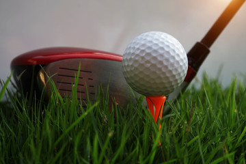 Golf ball and golf club in beautiful golf course at Thailand. Collection of golf equipment resting on green grass with green background