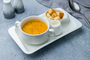 Soup cream of pumpkin on grey table