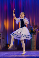 Young girls ballerina in a blue and white costume dancing performance on stage in a theater © Kozlik_mozlik