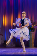 Young girls ballerina in a blue and white costume dancing performance on stage in a theater © Kozlik_mozlik