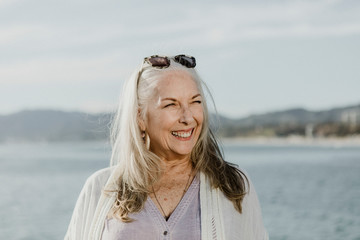 Senior woman smiling by the ocean