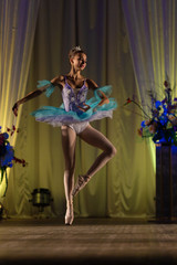 Young girl ballerina in a light blue dress tutu dancing performance of a ballet on stage in a theater © Kozlik_mozlik