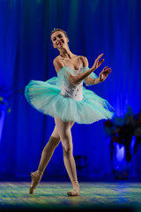 Young girl ballerina in a light blue dress tutu dancing performance of a ballet on stage in a theater © Kozlik_mozlik