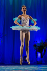 Young girl ballerina in a light blue dress tutu dancing performance of a ballet on stage in a theater © Kozlik_mozlik