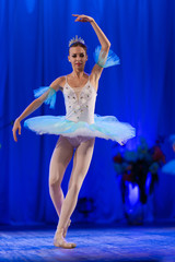 Young girl ballerina in a light blue dress tutu dancing performance of a ballet on stage in a theater © Kozlik_mozlik
