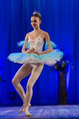 Young girl ballerina in a light blue dress tutu dancing performance of a ballet on stage in a theater © Kozlik_mozlik