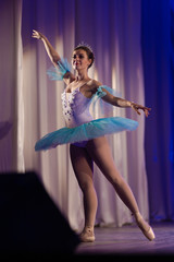 Young girl ballerina in a light blue dress tutu dancing performance of a ballet on stage in a theater © Kozlik_mozlik