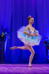 Young girl ballerina in a light blue dress tutu dancing performance of a ballet on stage in a theater © Kozlik_mozlik