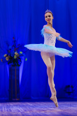 Young girl ballerina in a light blue dress tutu dancing performance of a ballet on stage in a theater © Kozlik_mozlik