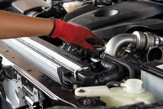 Mechanic check the radiator car. Hands of mechanic working in auto repair garage. Check and maintenance the water in radiator car with yourself. Service and maintenance vehicle.