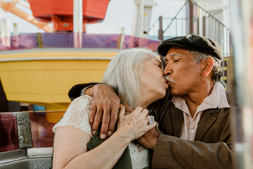 Happy senior couple kissing on a Ferris wheel