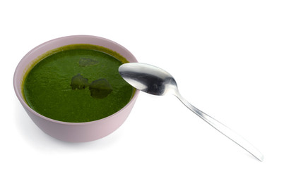 Spinach and other greens soup with vegetable oil in pink bowl. Isolated on white background..