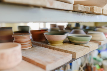 clay products are dried on shelves in a pottery workshop