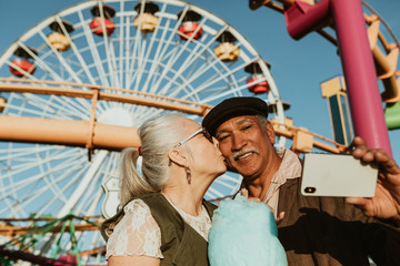 Senior couple taking selfie in a theme park