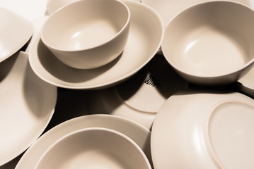 Set of empty and clean ceramic bowls and plates with simple round and curved shapes.