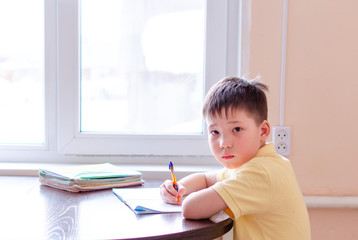 Asian child boy student in medical face mask homework online lesson at home, epidemic Coronavirus, MERS-CoV, 2019-nCoV, quarantine, Covid-19 self-isolation, online education, home schooling