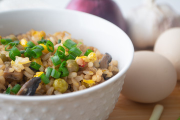 Chinese style vegetarian egg fried rice with sweet corn, green peas, onions, garlic, mushrooms and scallions