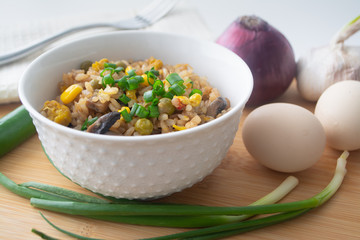 Chinese style vegetarian egg fried rice with sweet corn, green peas, onions, garlic, mushrooms and scallions
