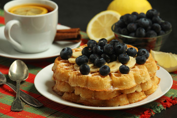 Belgian waffles with blueberry and a cup of tea with lemon