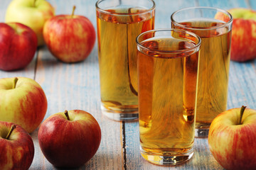 Glasses with apple juice and ripe apples