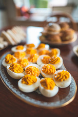 Delicious easter brunch with homemade sandwiches, buns and filled eggs on a wooden kitchen table 