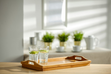 Mineral water on a wooden table in the morning sunlight with free space for an advertising product