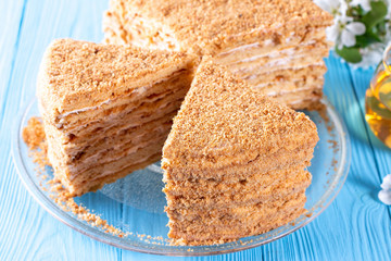 Homemade honey cake with sour cream on a wooden table