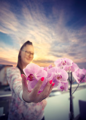 Girl hold orchidea at outside