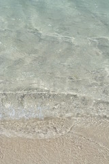 Transparent turquoise sea water, natural background. Sea surface in a turquoise lagoon. The texture of sea water. Summer and travel vacation concept.