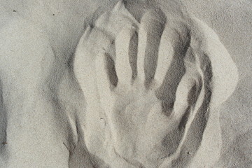 handprint in white sand