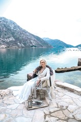 Beautyful bride sitting on a lake in winter mountances