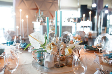 banquet table is decorated with plates, cutlery, glasses, candles and flower arrangements