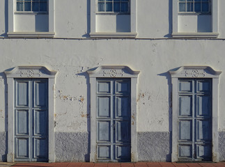 Fototapeta na wymiar Traditional colonial facade with repeated doors in the village of Los Llanos de Aridane. North of La Palma Island. Canary Islands. Spain.