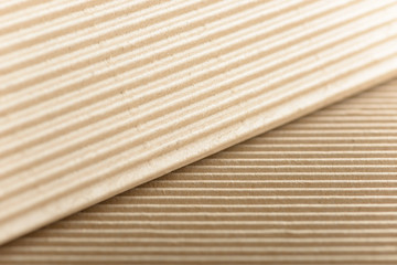 Carton or cardboard packing material. Texture of corrugated paper sheets made from cellulose. Supplies for creating boxes and packaging. Pasteboard background. Natural brown cardboard surface.