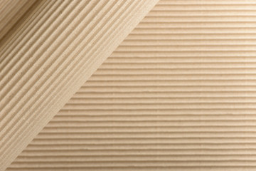 Carton or cardboard packing material. Texture of corrugated paper sheets made from cellulose. Supplies for creating boxes and packaging. Pasteboard background. Natural brown cardboard surface.