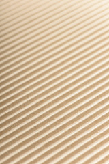 Carton or cardboard packing material. Texture of corrugated paper sheets made from cellulose. Supplies for creating boxes and packaging. Pasteboard background. Natural brown cardboard surface.