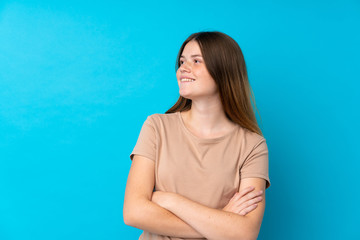 Ukrainian teenager girl over isolated blue background happy and smiling