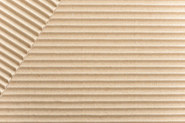 Carton or cardboard packing material. Texture of corrugated paper sheets made from cellulose. Supplies for creating boxes and packaging. Pasteboard background. Natural brown cardboard surface.