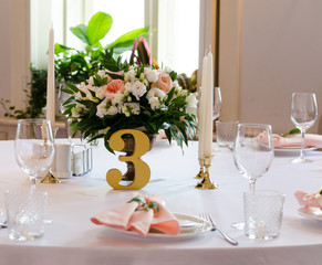 Table for wedding with white ang light pink flowers  in restaraunt 