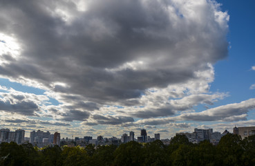 Fototapeta premium View of new buildings in residential areas surrounded by green trees and amazing blue sky with clouds in the capital of Ukraine Kyiv
