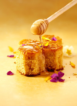 Honey cake with drizzled honey and flower petals