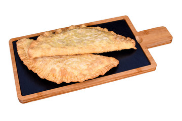 Cheburek with meat and suluguni cheese and greens on a wooden board. Cheburek - fried pie with meat and onions. isolated on white.