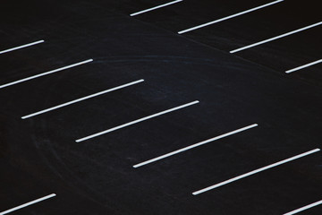 Empty parking during quarantine. White markings for cars on black asphalt.