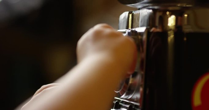 Toddler boy operating candy machine in candy shot - close up on hands